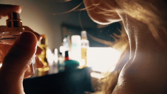 Beautiful woman spraying perfume on her neck. Slow motion close-up video