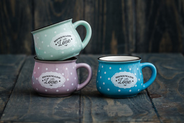 Colorful Ceramic Mugs with Enamel Look on Wooden Background