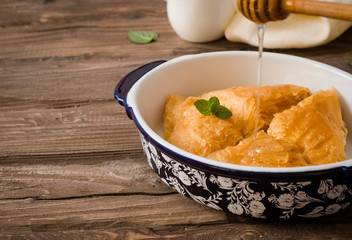 Homemade baklava stuffed cream with honey sirup on wooden table. Eastern sweets. Ramadan food