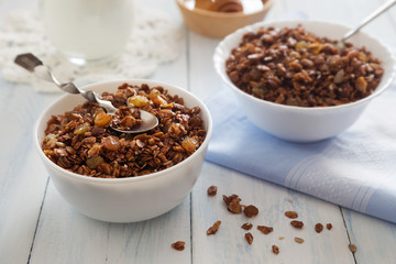 Bowls of granola with raisins and milk