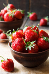 Fresh strawberry in a bowl on a wooden background