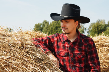 Naklejka na ściany i meble young cowboy near a haystack