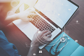 top view of smart medical doctor working with stethoscope and laptop and digital tablet computer on dark wooden desk with Vr diagram