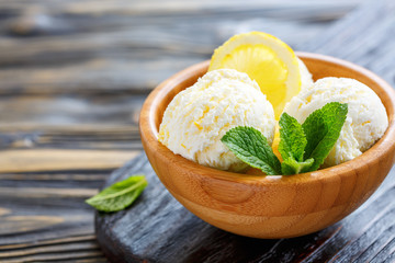Balls of lemon ice cream in a wooden bowl.