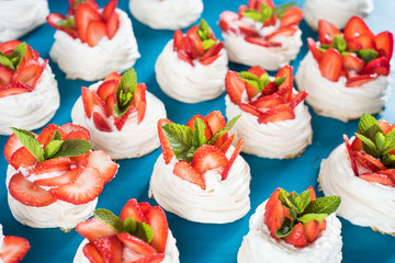 Homemade small strawberry pavlova meringue cakes pattern with cream top view