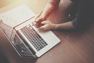 top view of  businessman hand working with laptop computer and mobile phone with VR business strategy concept on wooden desk