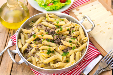 Pasta penne rigate with ground meat and onions in a pan