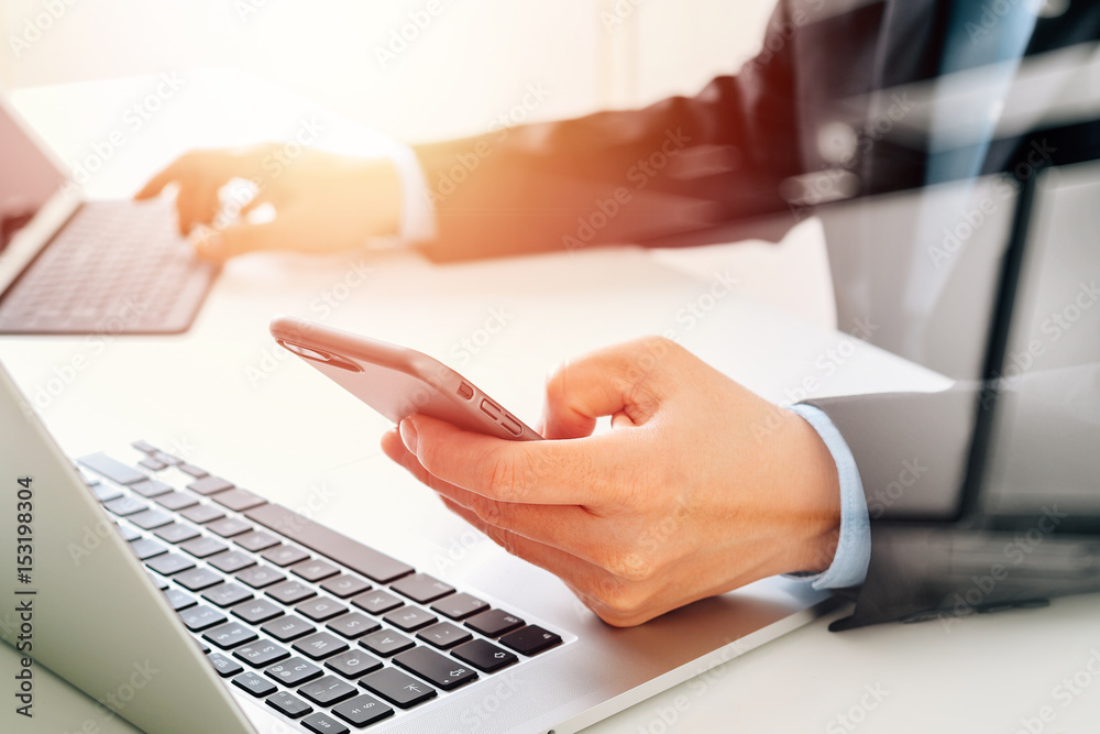 Aufkleber hands of businessman using mobile phone in modern office with laptop and digital tablet computer wit
