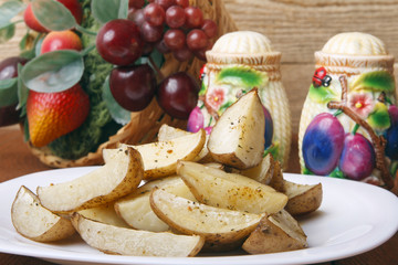 Baked potatoes on a white plate. Organic Vegetarian Food on wooden background