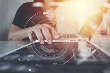 businessman working with mobile phone and digital tablet and laptop computer on wooden desk in modern office with virtual icon diagram