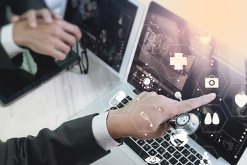 Medical co working concept,Doctor working with smart phone and digital tablet and laptop computer to meeting his team in modern office at hospital with virtual diagram