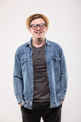 Portrait of attractive young man in hat and glasses over white background