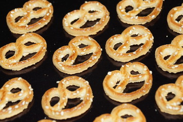 Sweet pretzel sprinkled with sesame seeds isolated on a black background