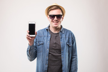Smiling attractive young tourist show mobile phone over white background