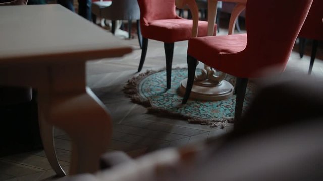 Man in stylish retro suit going between tables in the restaurant