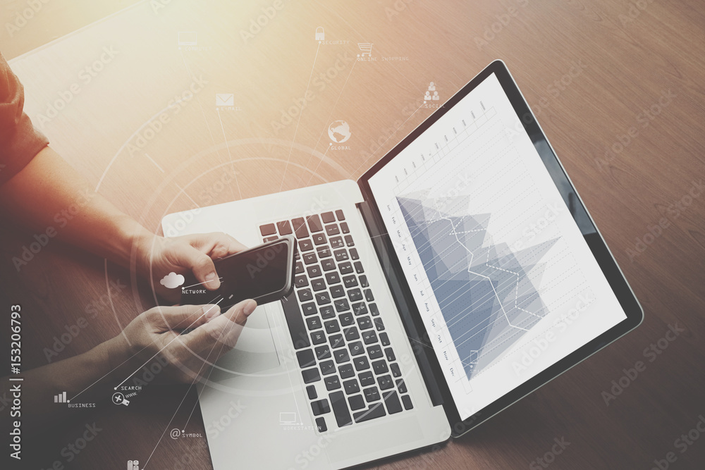 Poster top view of  businessman hand working with laptop computer and mobile phone with VR business strategy concept on wooden desk