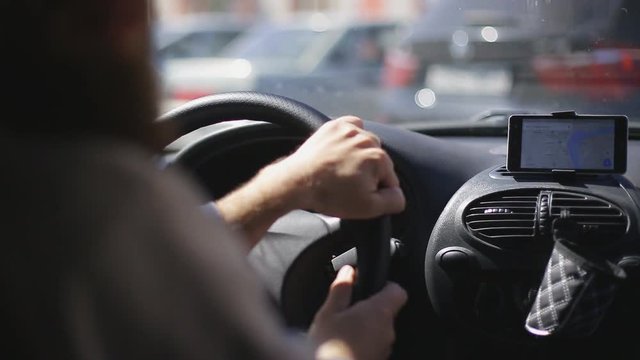 Man rides a car with a navigator on a smartphone