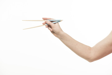 Hand with Chinese chopsticks and pencils