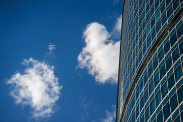 Fototapeta na wymiar Underside angle view to background of modern glass building skyscrapers over blue sky