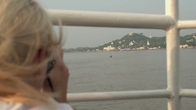 Ayeyarwady river, woman takes pictures from landscape on cruise ship