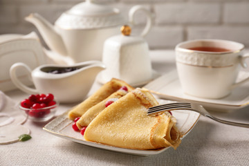 Plate with delicious pancakes and cranberry on table
