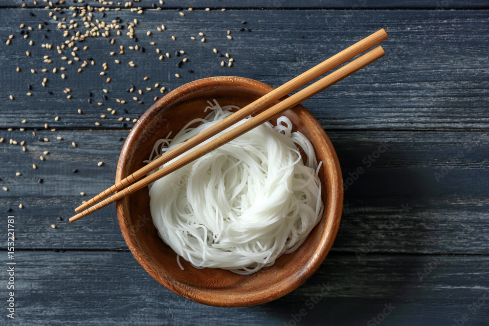 Sticker bowl with rice noodles on wooden table