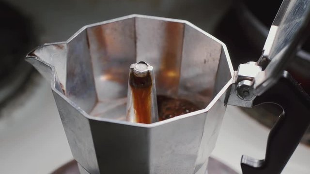 Moka pot brewing on a stove. Italian espresso coffee boiling in a moka pot close-up