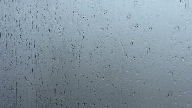 Background shot of rainy water drips on a window glass