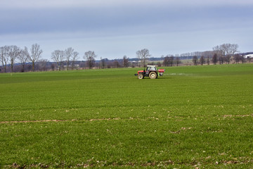 Tractor, photographed in the agricultural field during the processing of Pesticides - Poland