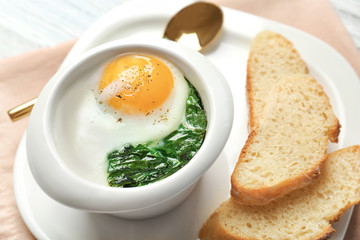 Plate with tasty egg and spinach, closeup