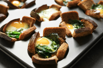 Baking mold with eggs and spinach, closeup