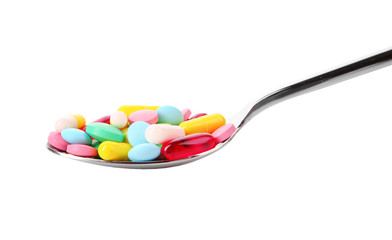 Diet concept. Spoon with pills on white background