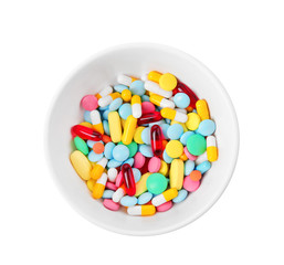 Diet concept. Bowl with colorful assorted pills on white background