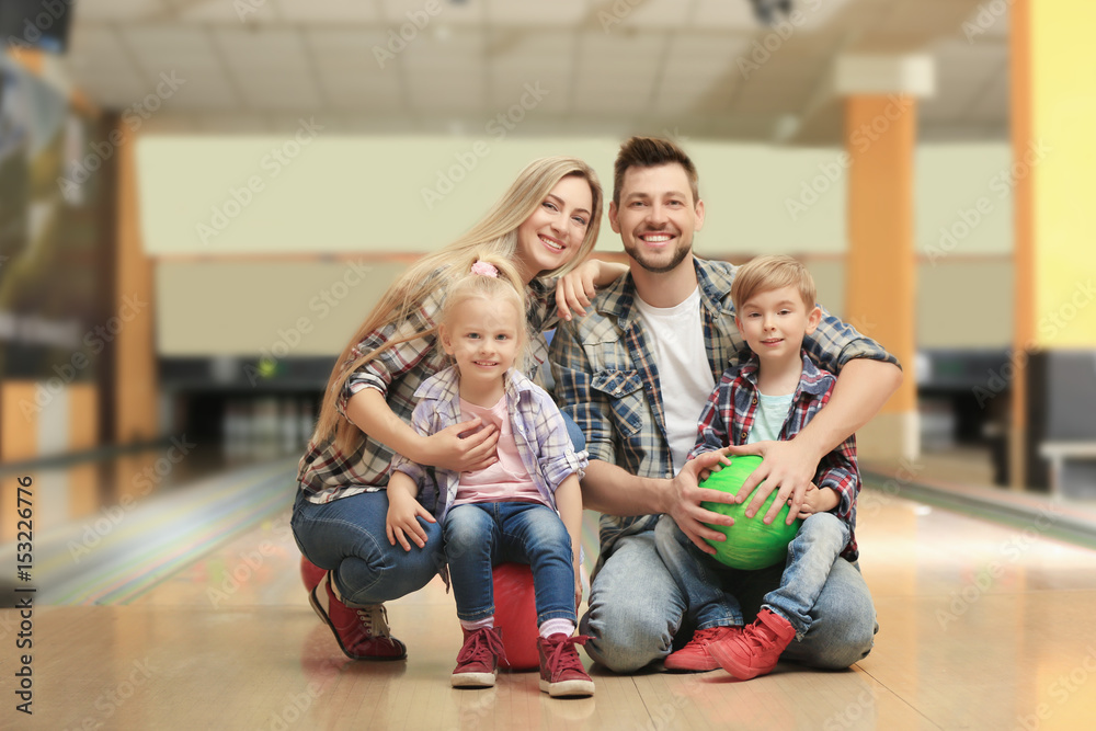 Poster Happy family sitting on floor in bowling club