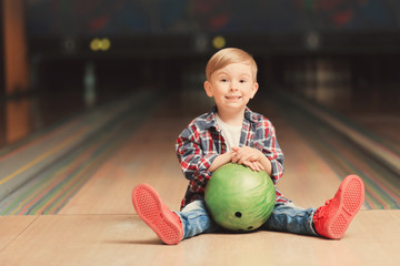 Fototapeta premium Cute child with ball in bowling club