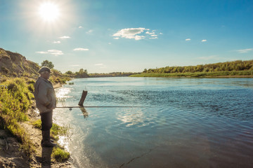 Fototapeta na wymiar Fisherman in the river landscape at sunset
