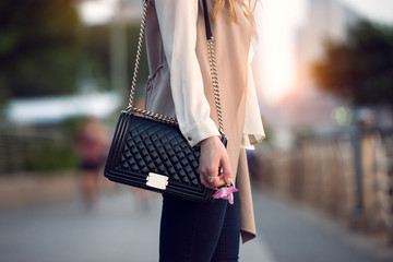 Close up of stylish female black leather bag outdoors. Fashionable and luxury style expensive female bag. - 153241742