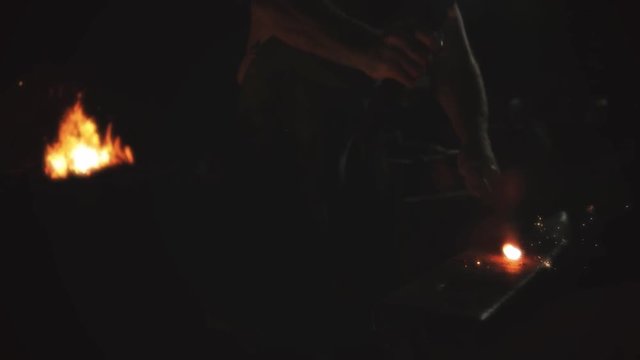 Blacksmith at Forge hitting metal sparks flying