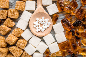 lumps of sugar with spoons sweet set on gray table background top view pattern
