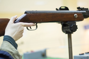 Female hand holding rifle with finger ready to pull the trigger