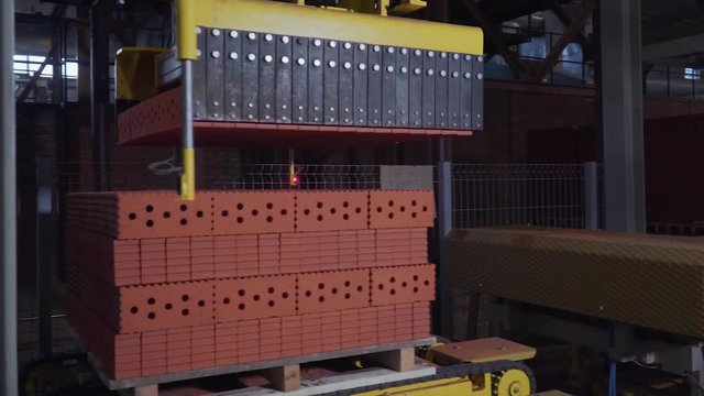 Plant for the production of bricks. Plant for production building material with ready brick, construction industrial. Production of bricks on plant. Workflow, close-up. Many bricks