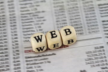 Web word built with letter cubes on newspaper background