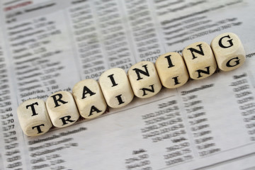Training word built with letter cubes on newspaper background