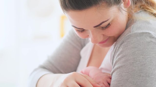 Breastfeeding concept. Young happy mother feeding her newborn baby. 4K UHD video 3840X2160