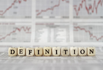 Definition word built with letter cubes on newspaper background