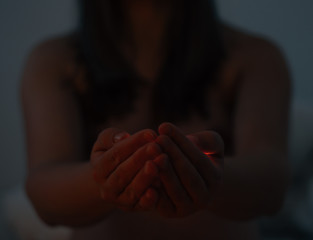 Young woman holding light with both hands bare shoulders