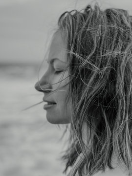 Young woman close up with wind in hair eyes closed profile
