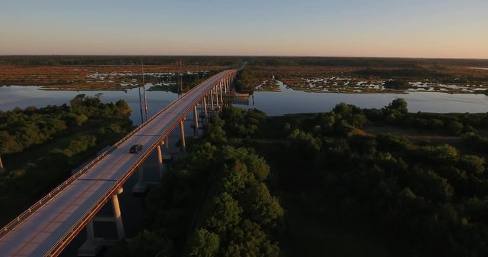 An early morning sunrise aerial establishing shot of the Topsail Island Bridge over the Intracoastal Waterway.  	
