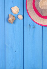 Straw hat and seashells on boards, accessories for vacation, copy space for text