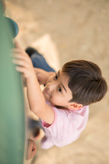 Fototapeta na wymiar Little boy climbling up at playground